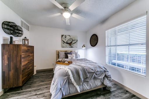 a bedroom with a bed and a ceiling fan