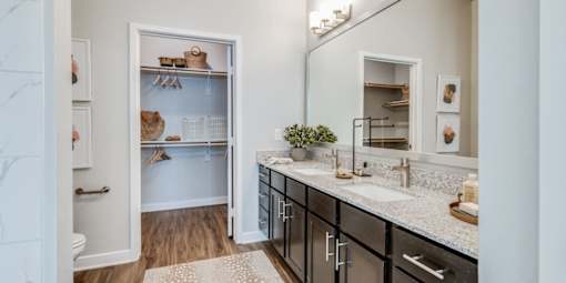 A bathroom with a white cabinet and a mirror above it.