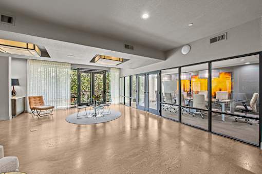 a large living room with glass windows and a table and chairs