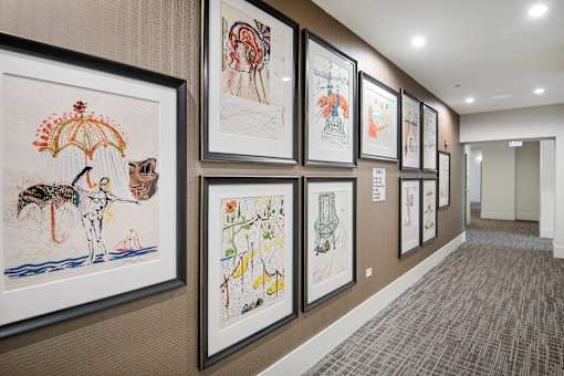 A hallway with framed artwork on the wall.
