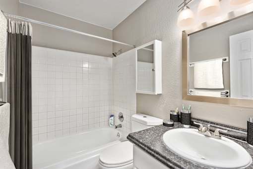 A white toilet sits next to a white sink in a bathroom.