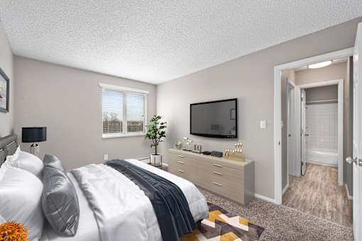 A bedroom with a bed, nightstand, and television.
