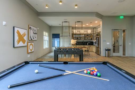 A pool table with a white ball and a set of cues on it.