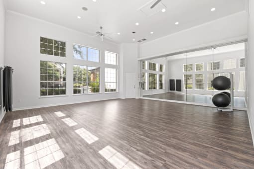 a large living room with hardwood floors and large windows
