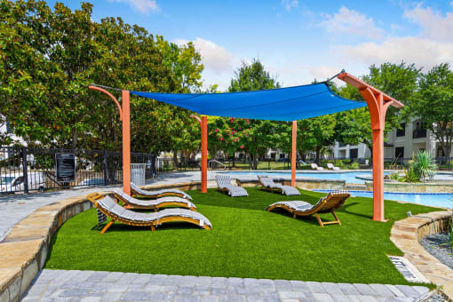 a group of lounge chairs sitting on top of a lush green field