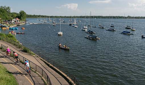 A group of people are riding bikes on a path next to a body of water.