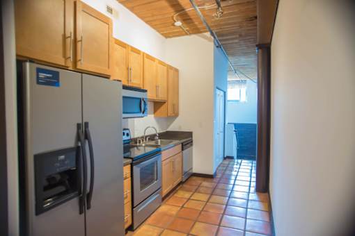 A kitchen with a refrigerator, oven, and microwave.