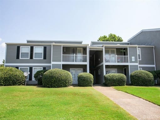 an apartment building with a sidewalk in front of it
