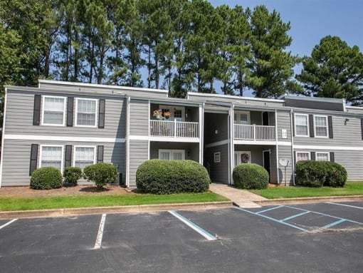 an apartment building with balconies and a parking lot