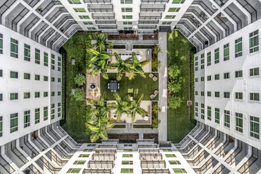 an overhead view of a building with a garden in the middle