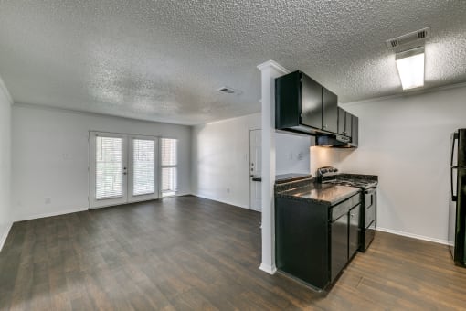 the living room and kitchen of an empty apartment with a stove and refrigerator