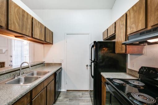 an empty kitchen with a sink and a refrigerator