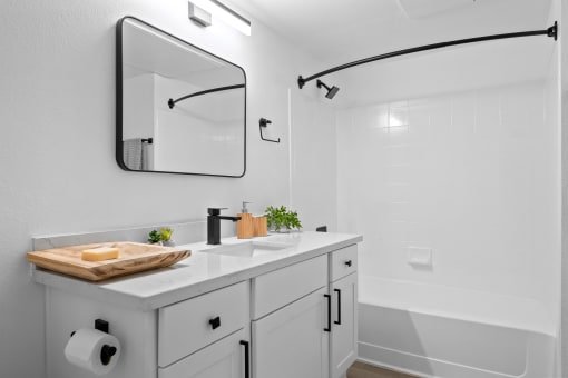 a white bathroom with a sink and a mirror