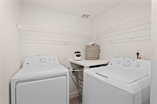 two white washers and dryers in a white laundry room