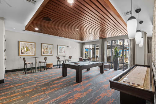 a spacious game room with a pool table and a bar