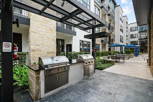 A patio with a grill and a no smoking sign.