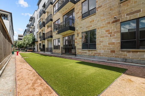 an apartment building with a green lawn in front of it