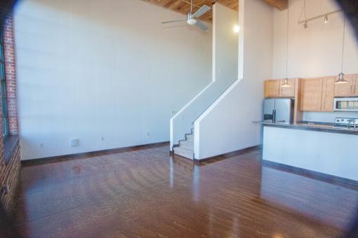 A room with a staircase and a kitchen area.