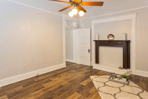 A room with a fireplace and a rug on the floor.