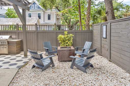 Two chairs and a table are in a backyard.