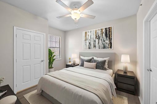 A bedroom with a large bed and a ceiling fan.
