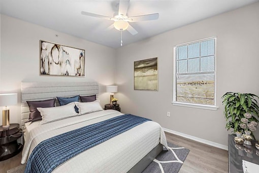 A bedroom with a bed, nightstands, and a ceiling fan.