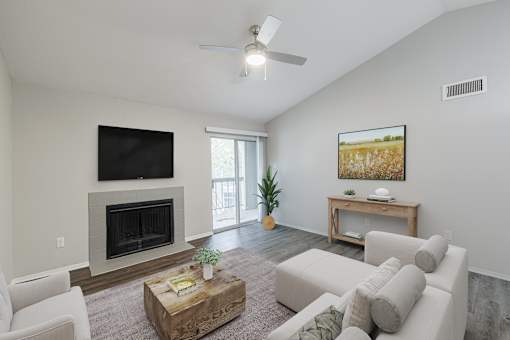 A living room with a fireplace and a flat screen TV mounted on the wall.