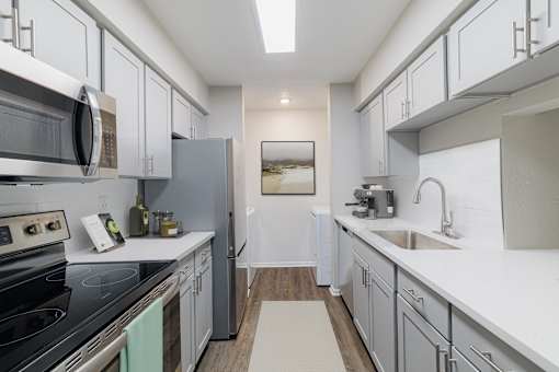 A modern kitchen with white cabinets and a stainless steel oven.