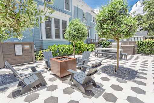 A patio with a checkered floor and grey chairs.