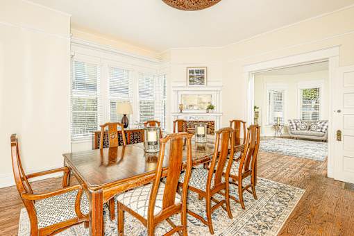 A dining room with a wooden table and chairs.