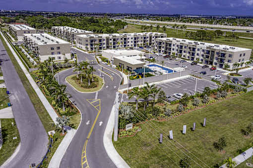 A road with a yellow line curves to the right in front of apartment buildings.