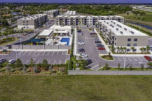 A large parking lot is surrounded by apartment buildings.