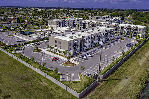 A large apartment complex with a parking lot in front.