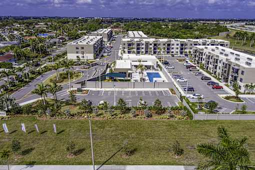 A large apartment complex with a parking lot in front.
