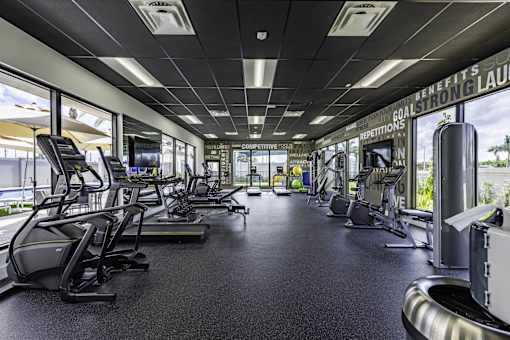 A gym with treadmills, elliptical machines, and other exercise equipment.