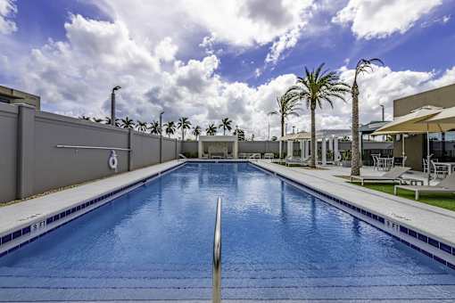 A large indoor swimming pool with a blue tiled edge and a white starting block.