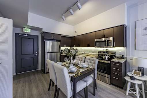 A modern kitchen with a dining table set for two.