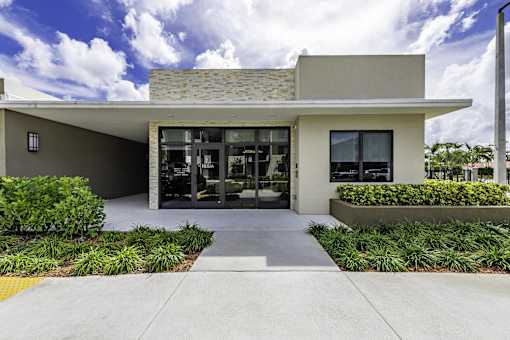 A modern building with a stone roof and glass doors.