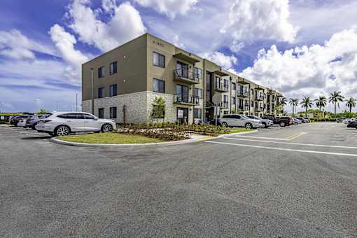 A parking lot in front of a building with a car parked in it.