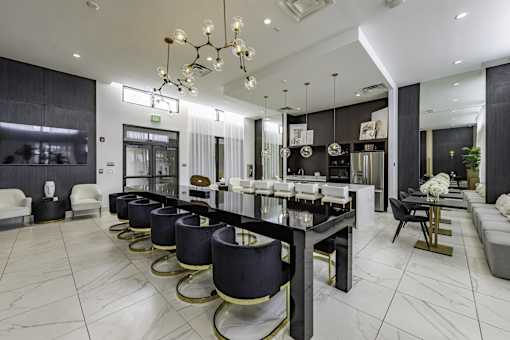 A modern dining room with a long table and chairs.