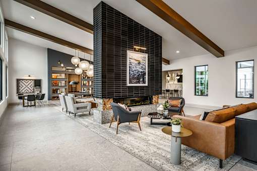 A modern living room with a large couch and a fireplace.