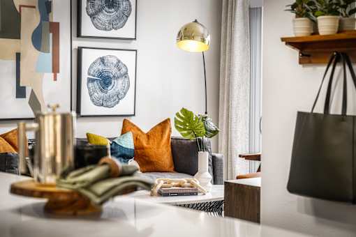 A living room with a couch, a table, and a lamp.