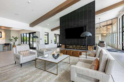 A modern living room with a large flat screen TV mounted on the wall.