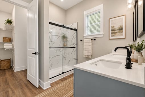 A bathroom with a white sink and a glass shower door.