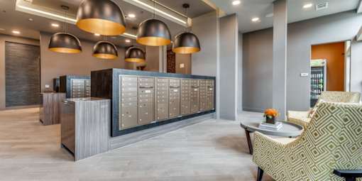 A reception area with a desk, chairs, and a row of lockers.