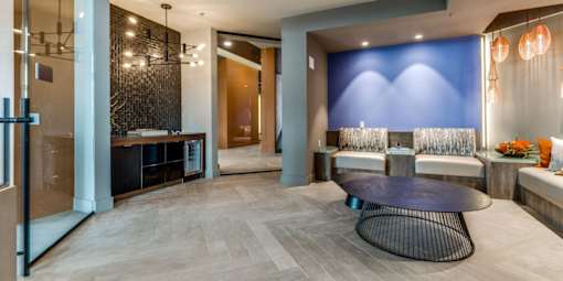 A modern living room with a black coffee table and a blue accent wall.
