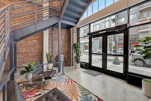 A modern interior with a staircase and a colorful rug.