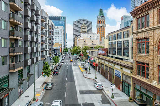 A city street with cars and buildings on either side.
