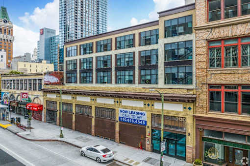 A street view of a city with a building that has a "No Leasing" sign.