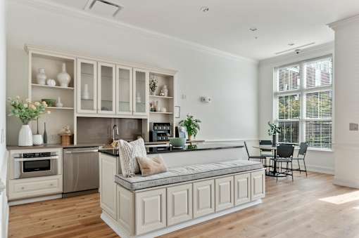 A kitchen with a white island and wooden floors.